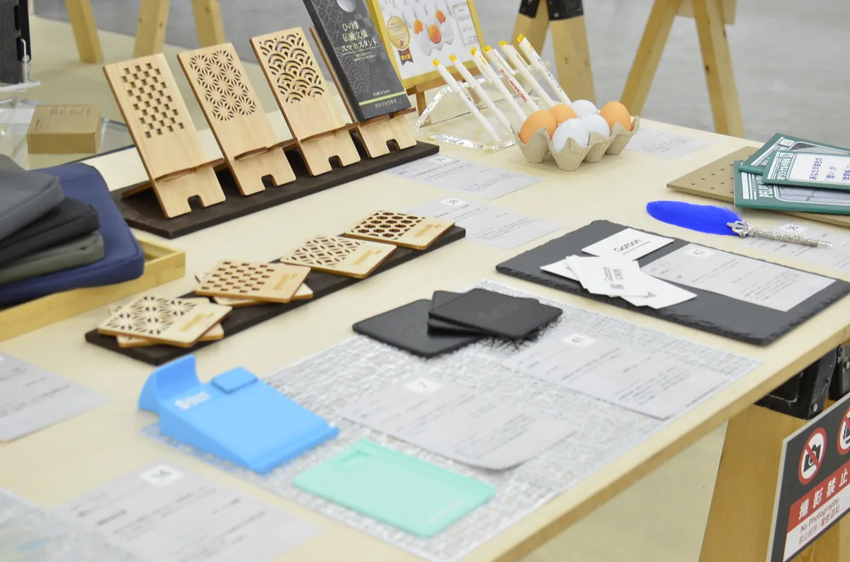 大賞「ひのき間伐材伝統文様スマホスタンド」と準大賞「.Garbon（コースター）」の展示